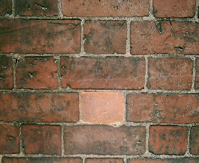 Brick wall with wrong coloured replaced brick