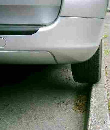 Car parked on edge of kerb. Tyre overhangs it