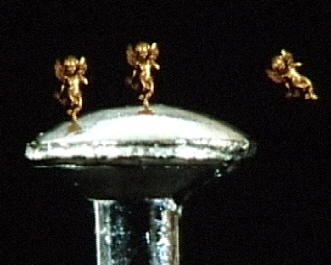 Close up photo of a pin head with three angels on it