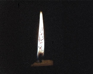 A candle burning with the outline of a nude woman in the flames
